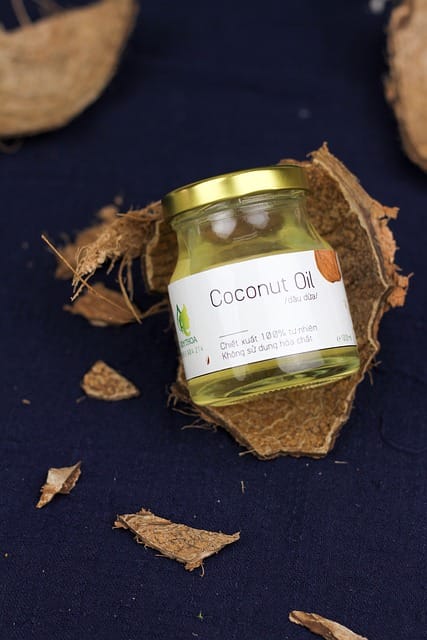 Huile de coco posée sur une écorce de noix de coco cassée